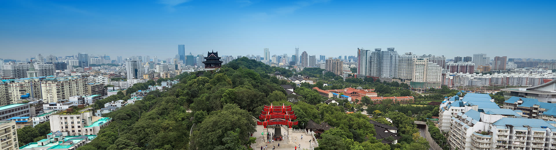 Ciel bleu au-dessus d'un parc vert et de la ville tentaculaire de Wuhan.