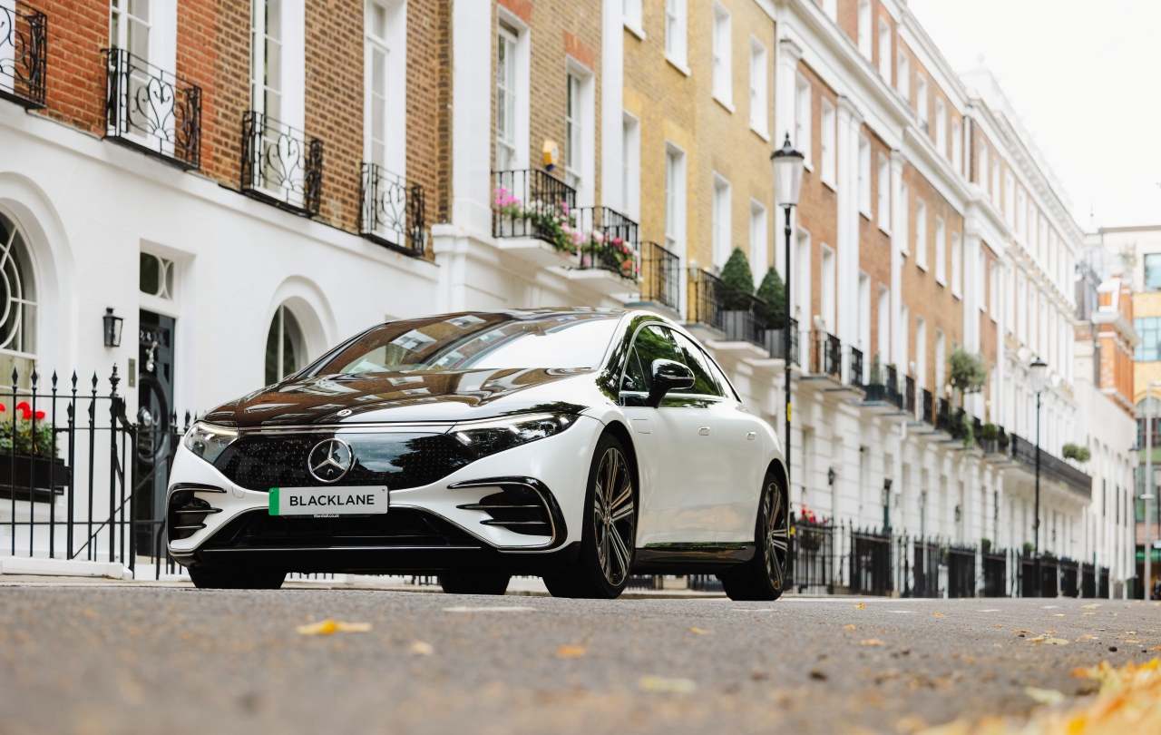 A two-tone Mercedes EQE car from chauffeur company Blacklane sits on the beautiful streets of London's Chelsea.