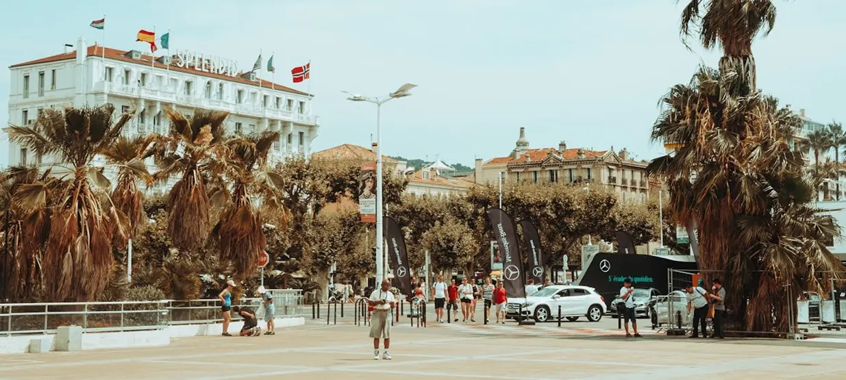 View of a street in Cannes, France during a festival, with a Mercedes promotion taking place outside the Hotel Splendide.