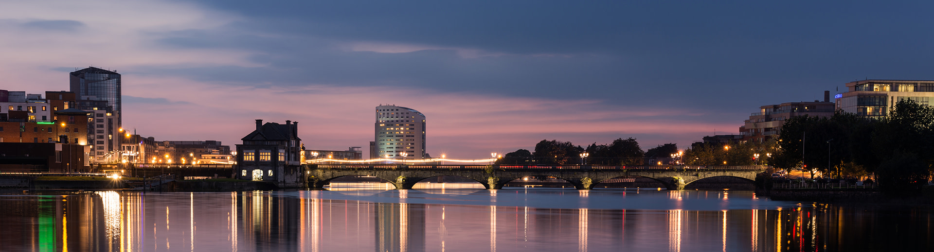 In the early evening, the skyline of Limerick stands silhouetted against the sky.