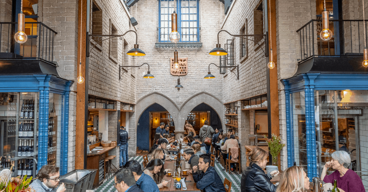 <figcaption>Communal tables at Republique. <em>Image credit: Jakob Layman</em></figcaption>