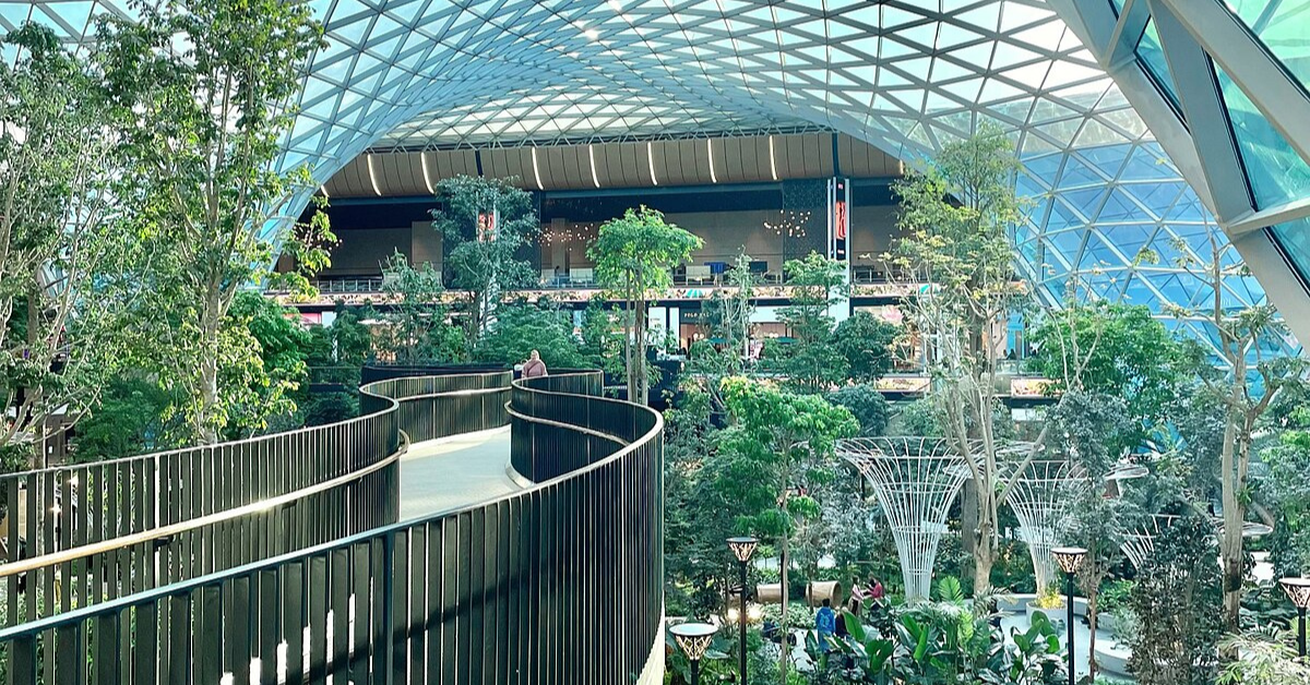 <figcaption class="wp-element-caption">The Orchard at Hamad International Airport offers travelers a serene retreat with lush greenery and calming water features. <em>Image credit: Wikimedia</em></figcaption>