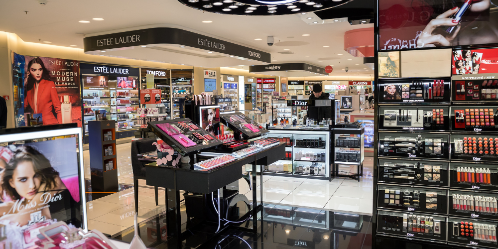 Luxury duty free beauty section showcasing premium cosmetics and skincare products from brands like Estée Lauder, Dior, and Chanel.