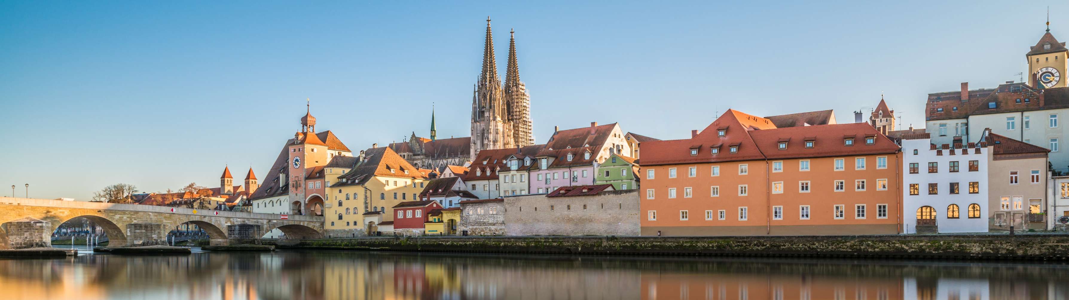 Historic buildings sit alongside the river in the picturesque town of Regensburg.