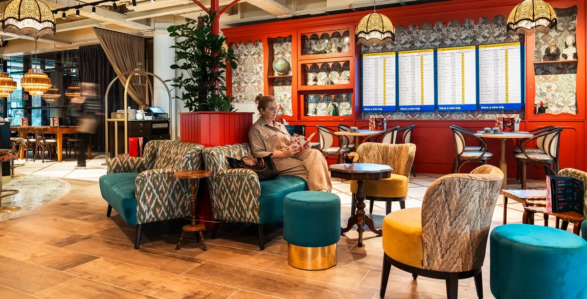 Shot of a woman in the quirky seating area of The Wanderer Lounge in Amsterdam's Schiphol airport.