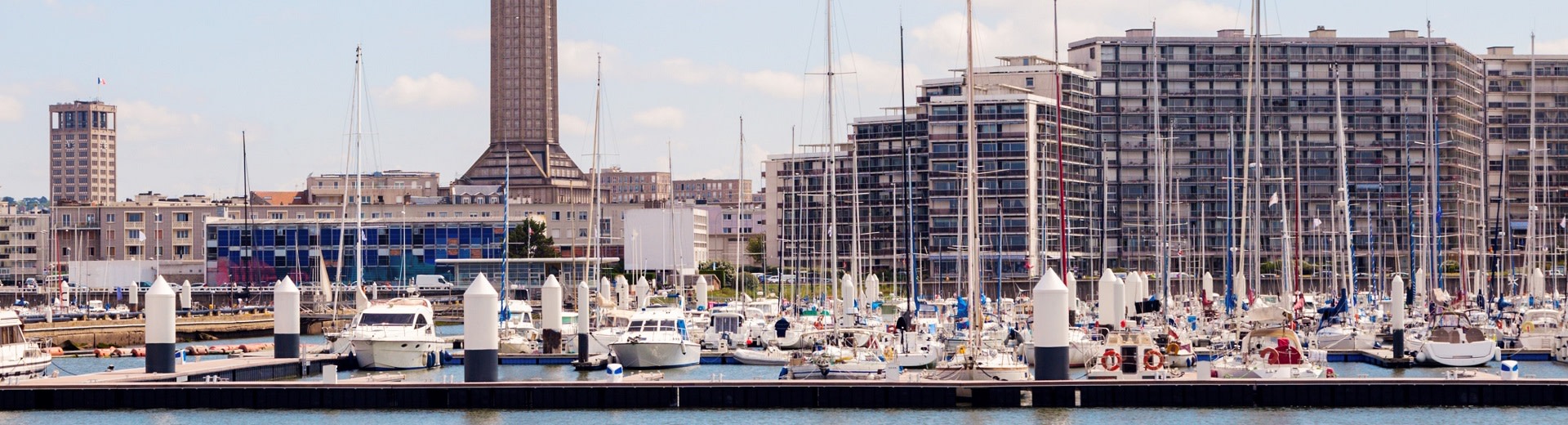 A picture of Le Havre with the masts of yachts and the tower of Saint Joseph's Church