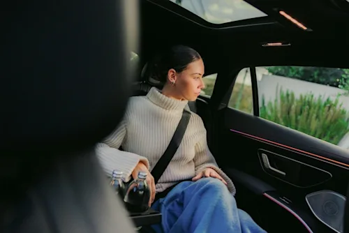 A female passenger looks out the window from the back seat of a luxury Blacklane chauffeured car.
