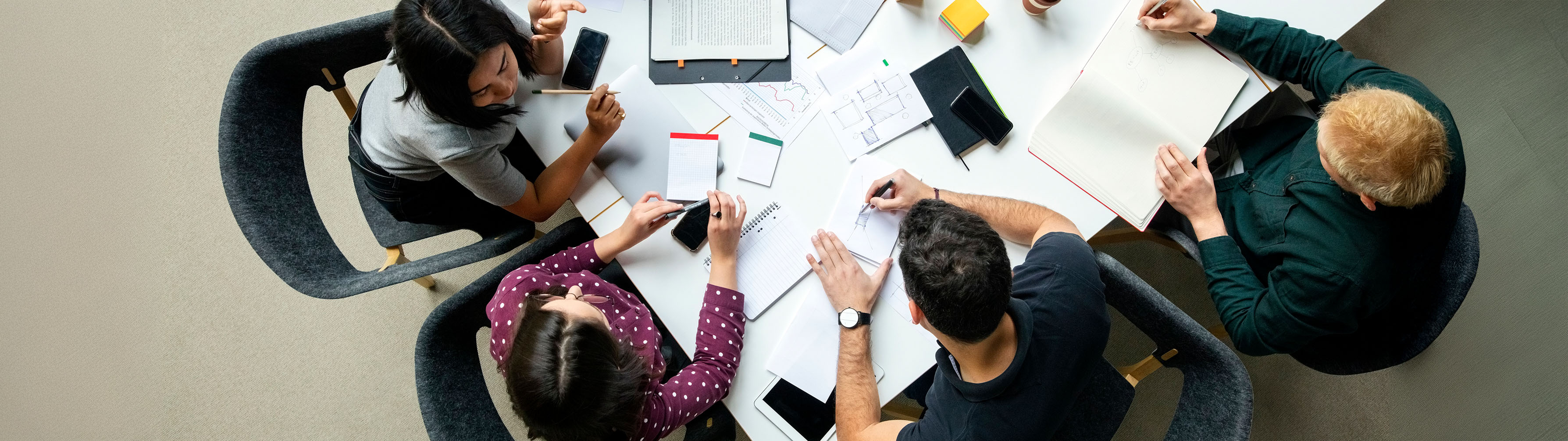 Birds-eye view of four office employees working at a table