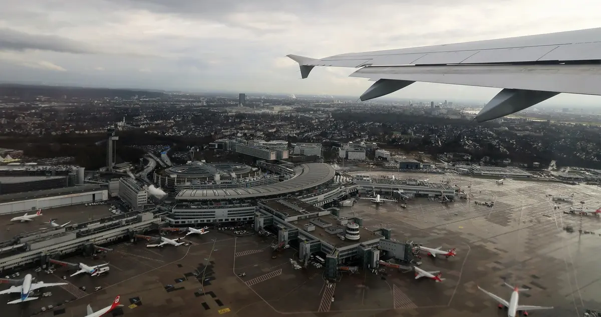 Shot of Duesseldorf Airport from an airplane, showing the left wing of the plane in the right of the picture.