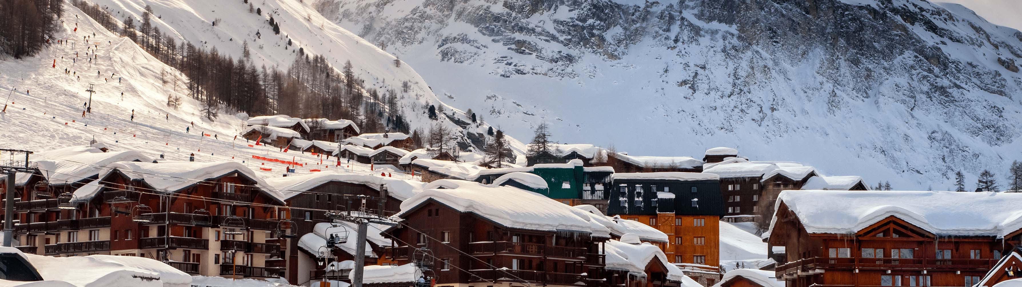 The chalets and cabins of Val d'Isere lie before pristine, snow-covered slopes.