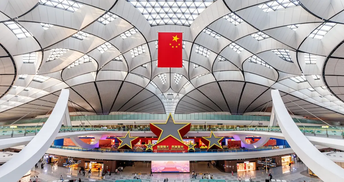 Terminal of Beijing Daxing International Airport (PKX), showing the Chinese flag and gigantic stars inside the building itself.