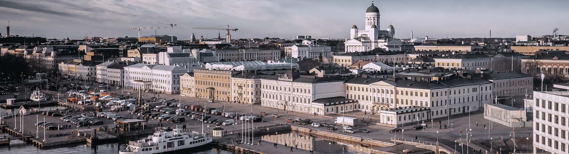 Des bâtiments à l'aspect carré le long du rivage d'Helsinki par une journée nuageuse.