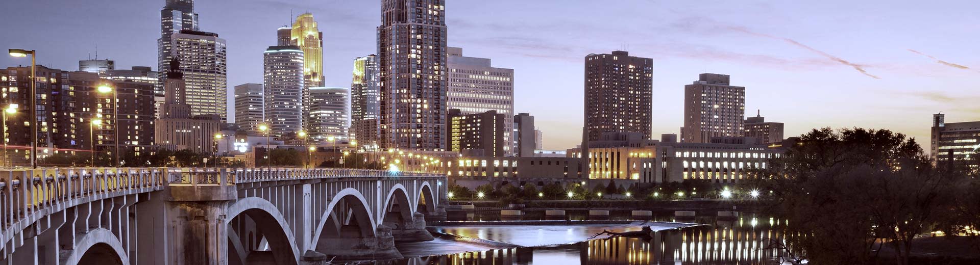 Un puente y rascacielos de gran altura iluminan el cielo sobre Minneapolis.