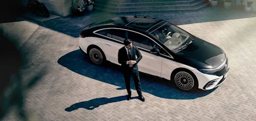 Blacklane chauffeur assisting a passenger through the airport by wheeling her luggage