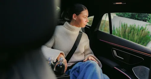 A female passenger looks out the window from the back seat of a luxury Blacklane chauffeured car.