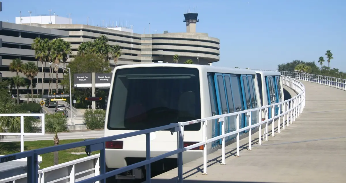 Shot of the monorail system at Tampa airport, with one of the terminal buildings and the air traffic control tower in the background.