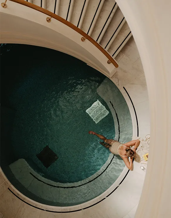 Overhead shot of a woman relaxing in one of the pools at the Eynsham Spa at Estelle Manor Hotel.
