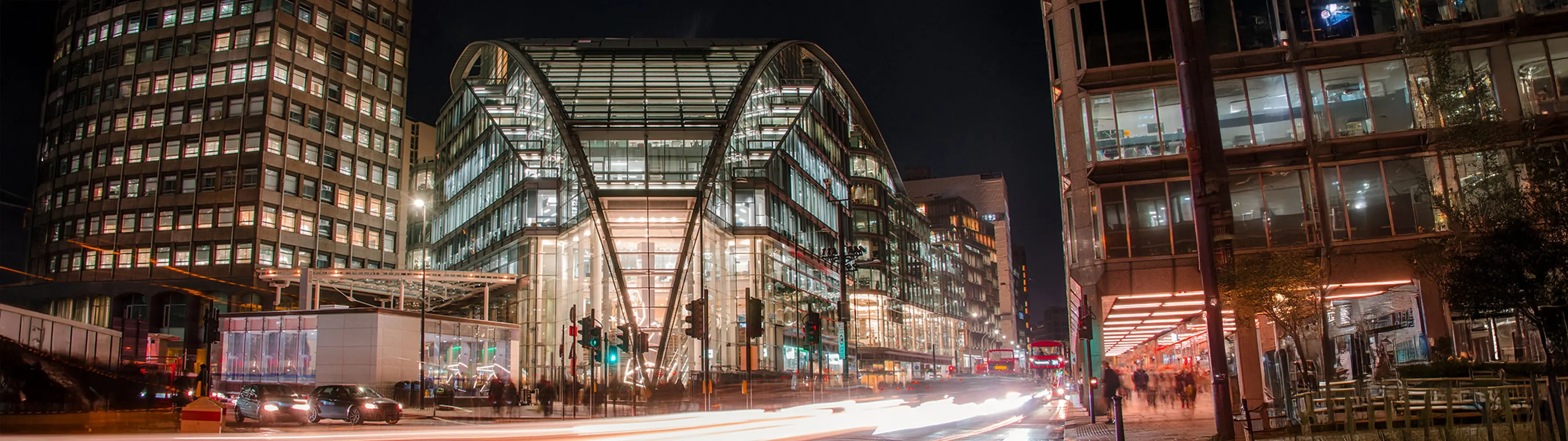 Exterior slow shutter shot of London's Victoria Station lit up at night.
