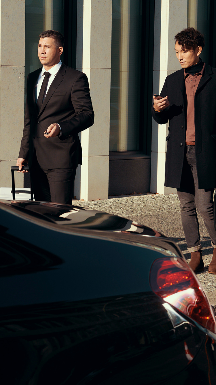 Un passager vérifie son téléphone alors qu'il est guidé par son chauffeur.