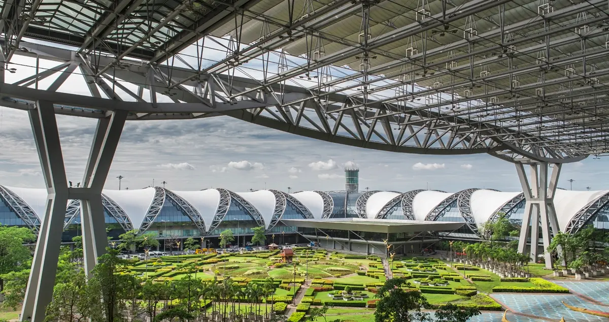 Shot of the steel and glass terminals of Bangkok Airport, surrounding the central garden areas it surrounds.