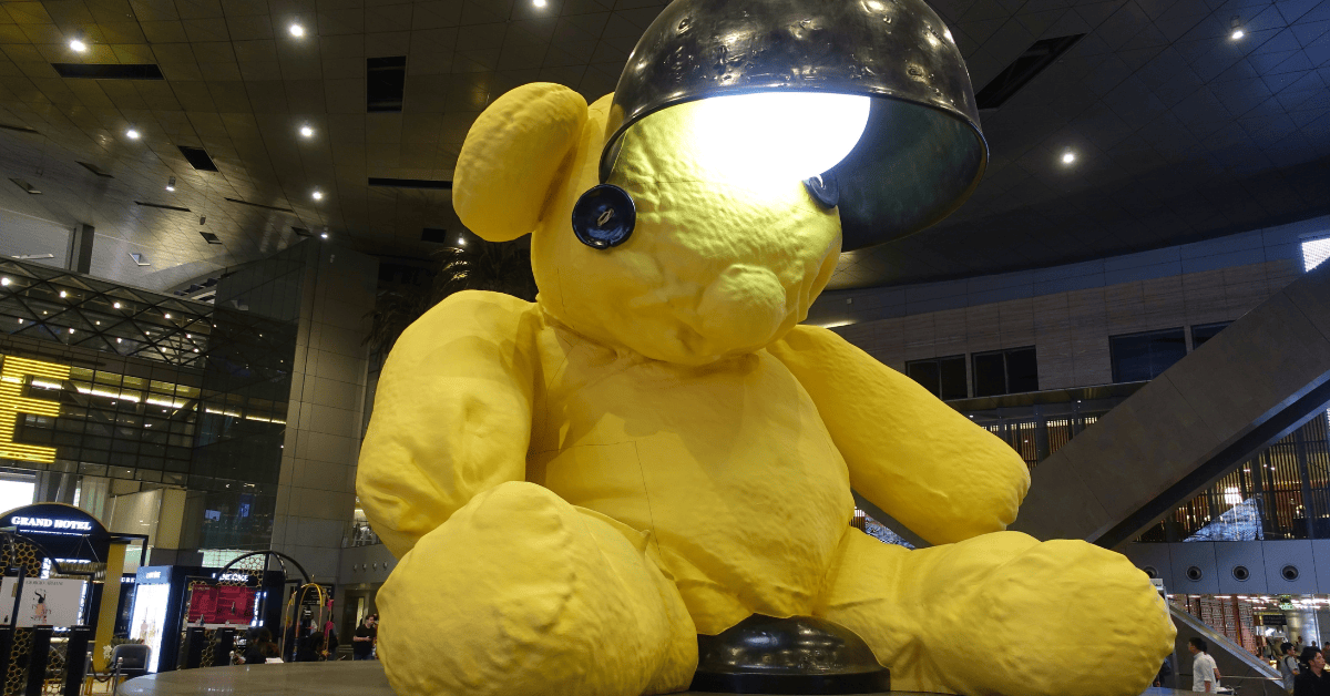 <figcaption class="wp-element-caption">Hamad Airport's iconic 23-foot yellow teddy bear sculpture by Urs Fischer. <em>Image credit: David McKelvey/Flickr</em></figcaption>