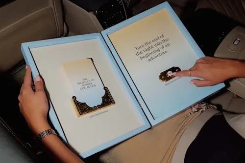A woman's handing pushing Blacklane London's Shortcut to Summer magic button in the backseat of a chauffeured car.