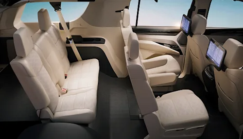 Shot of the interior of a Blacklane Business SUV vehicle, showing 4 pale leather seats with screens.