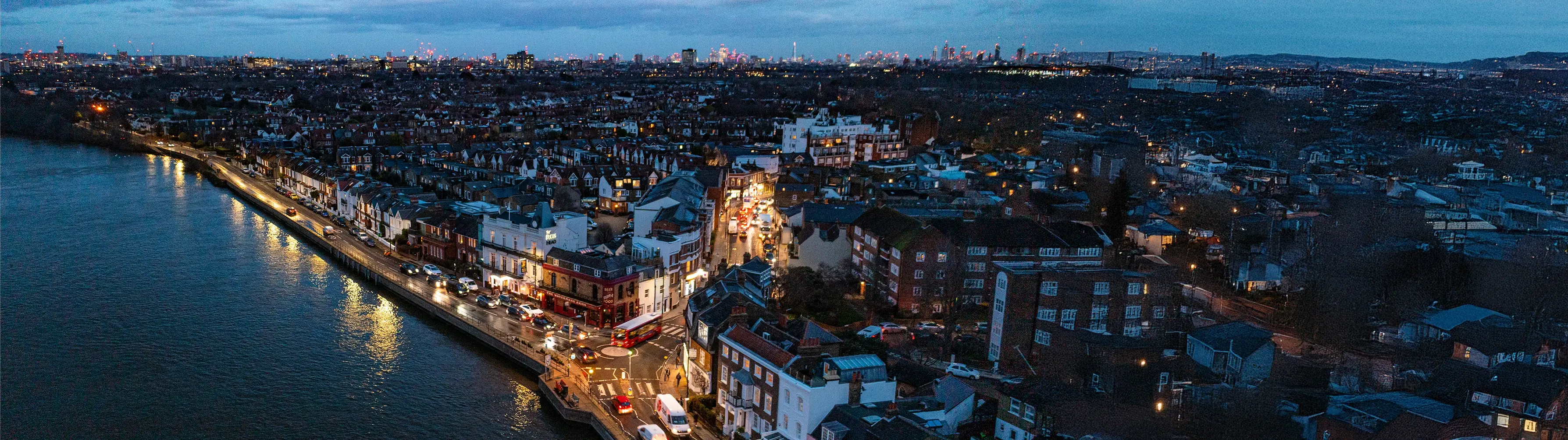 Aerial shot of Barnes at night, with London's skyline in the distance.