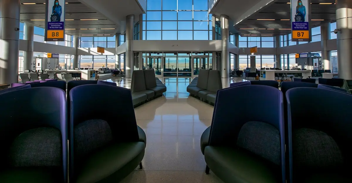 Comfortable seating in an empty area of Denver International Airport, with departure gates in the background.