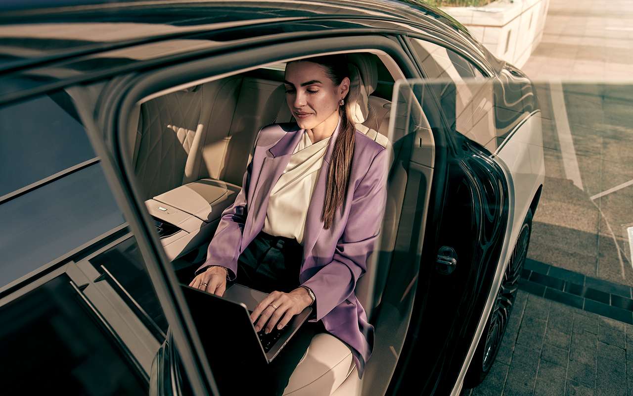 A businesswoman sits in the back seat of a Blacklane limo.