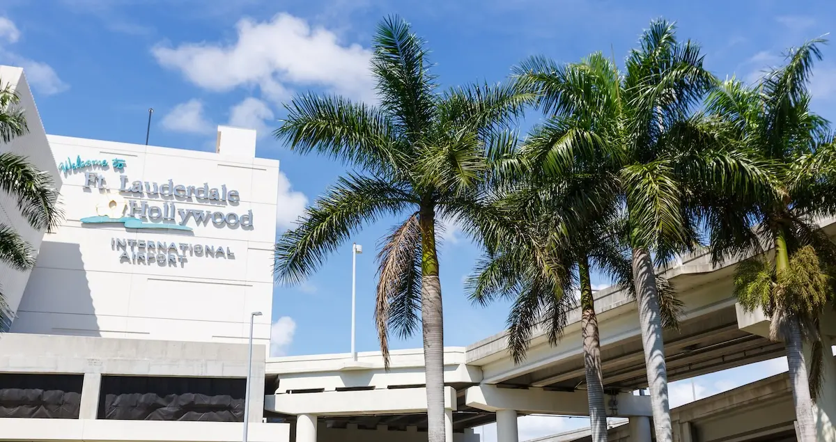 Exterior of Fort Lauderdale-Hollywood International Airport terminal building with palm trees in the foreground.