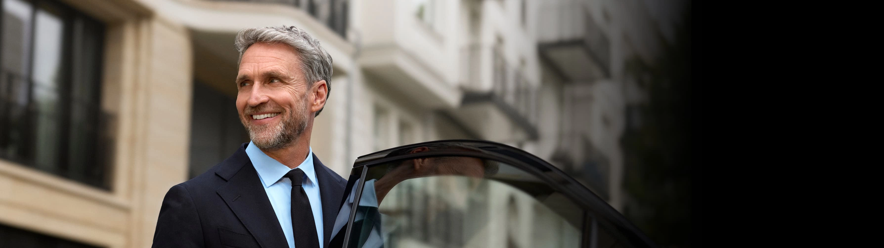 Un chofer sostiene que abre la puerta del auto mientras una mujer entra.