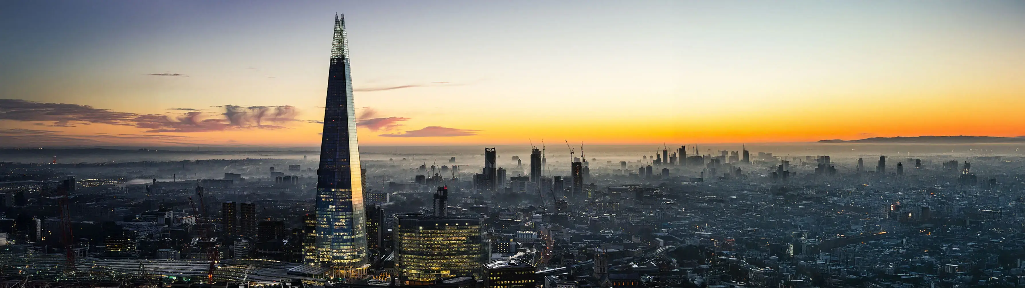 London's Shard skyscraper rising about the morning mist of the city skyline at dawn.