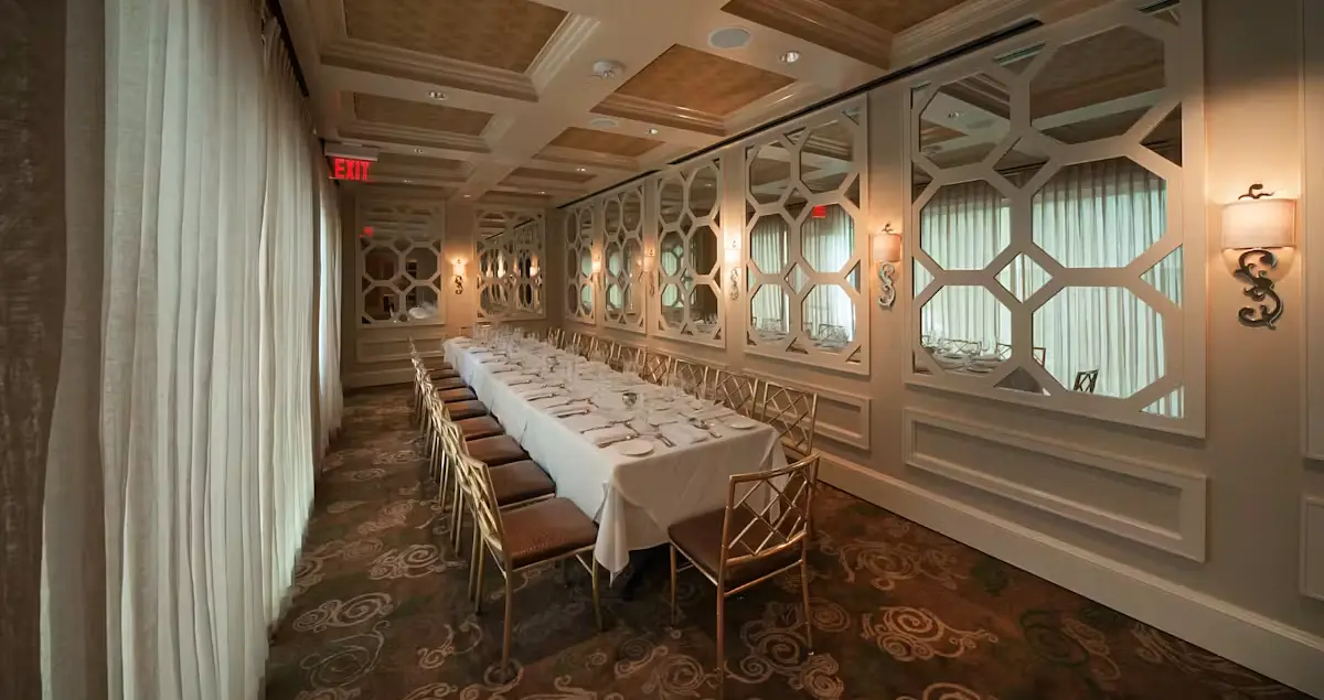 A long dining room table in Brennan's private dining restaurant in Houston, with a long window and mirror behind it.