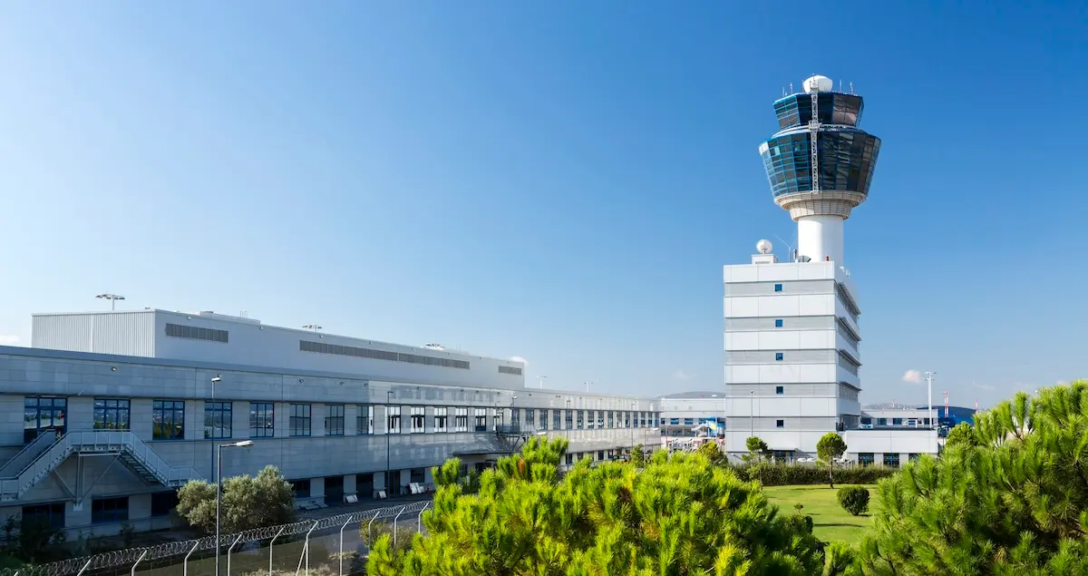 Exterior shot of the terminal building of Athens AIA Airport, with the control tower visible on the right.