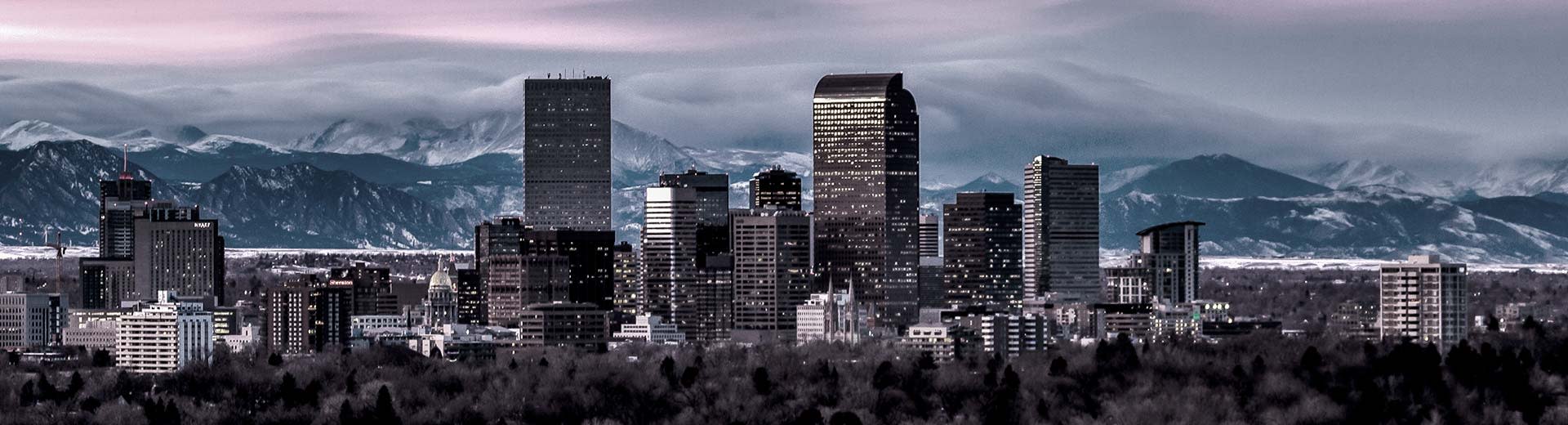 Die Stadt Denver, mit den Rocky Mountains im Hintergrund und Wolkenkratzern im Vordergrund.