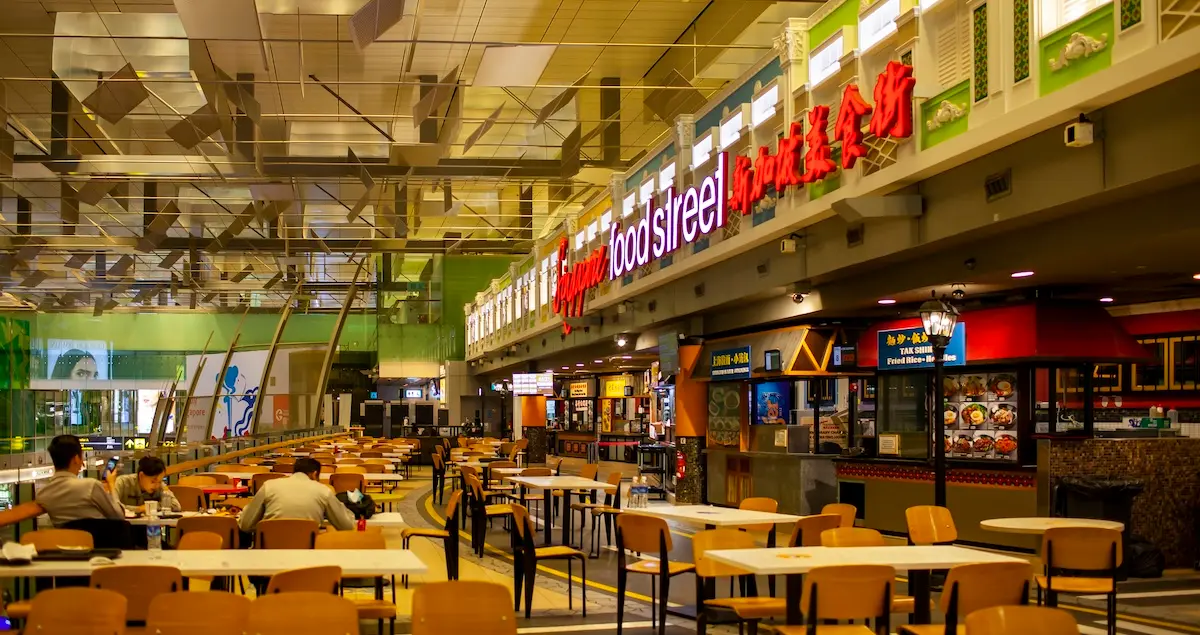 Food Street foodcourt Inside Of Terminal 3 Of Changi Airport, Singapore, showing tables and restaurant kiosks.