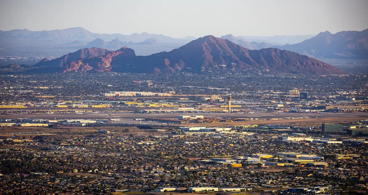 A view of Phoenix Sky Harbour Airport from above, showing the mountains in the background.