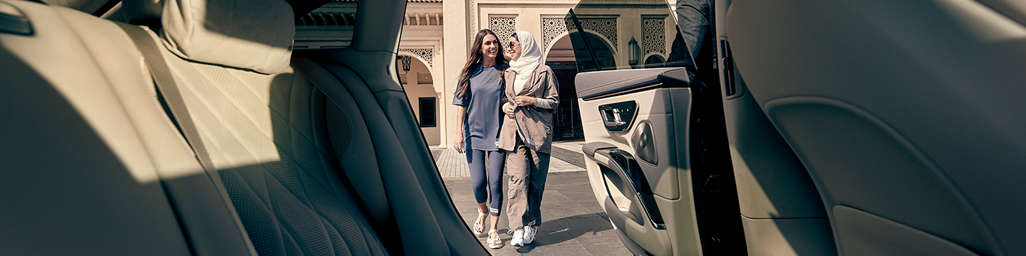 Hero image, two Emirati women walking to back seat