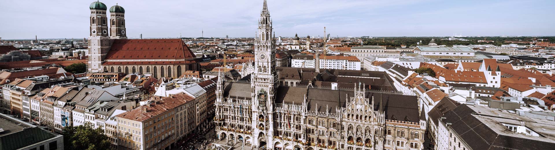 Ein wunderschöner Stadtplatz in München an einem klaren Tag mit Kirchenstürmen dominiert die Skyline.