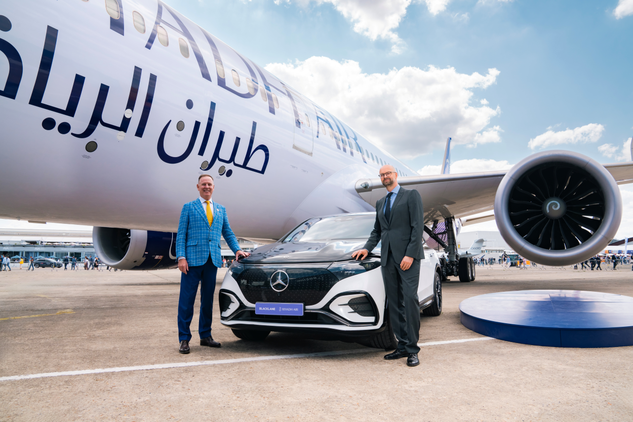 A Blacklane Mercedes limo sits on the runway beside a Riyadh Airways jet plane, with the two CEOs standing beside it.