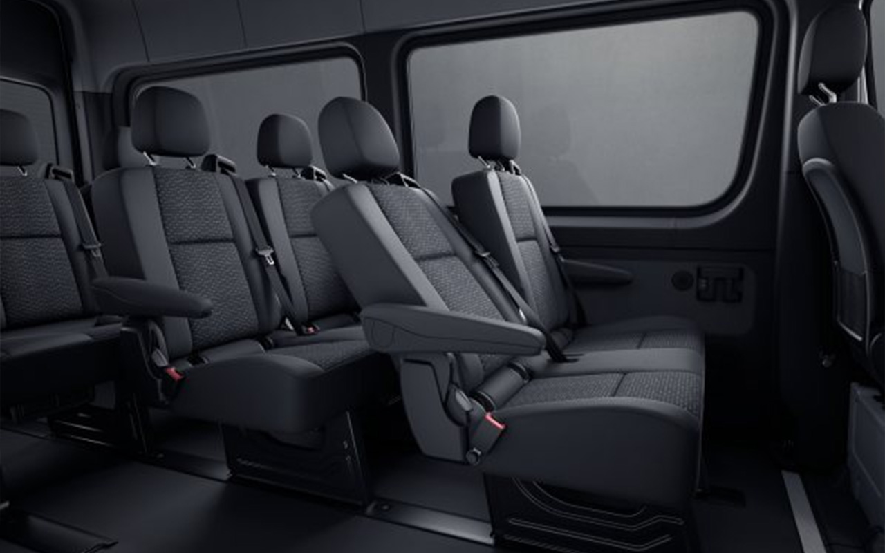 The interior of a Mercedes Sprinter Van with seats for 12.