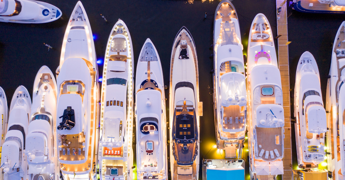 Top-down view of luxury yachts lined up at the Fort Lauderdale Boat Show at night.