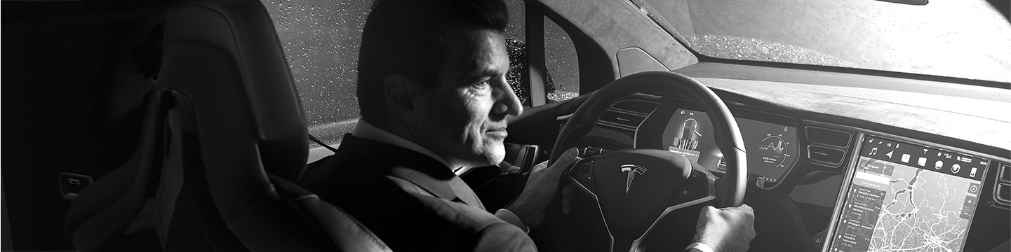 Male chauffeur driving Tesla, header dimensions
