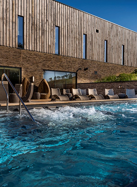 Exterior shot of the pool and the modern building at spa hotel South Lodge outside London.