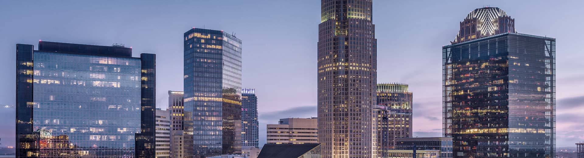 Los rascacielos del centro de Charlotte iluminan el cielo durante la puesta del sol.