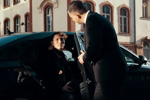 Chauffeur opens the door for guest getting out of the car