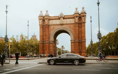 A black Mercedes from chauffeur service Blacklane drives past the Arc de Triumpf in Barcelona.