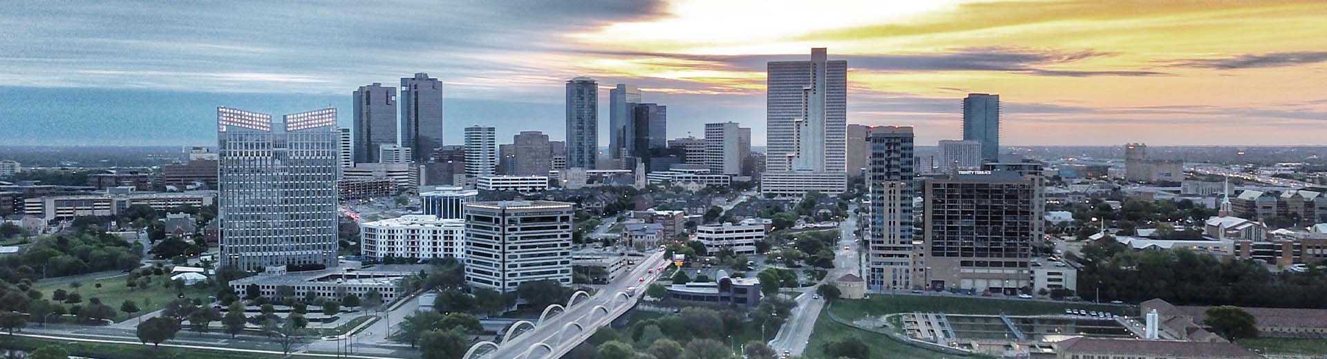 Beautiful Fort Worth skyline, with skyscrapers silhouetted against a yellow sky.