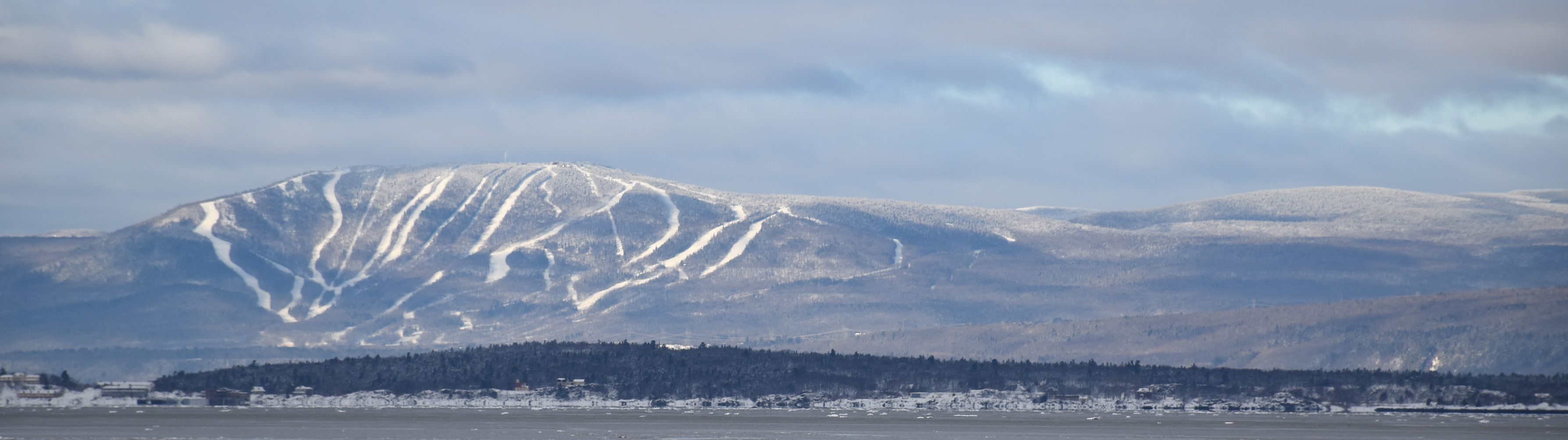 The white valley and mountain slopes of Mont Sainte Anne on a clear day.